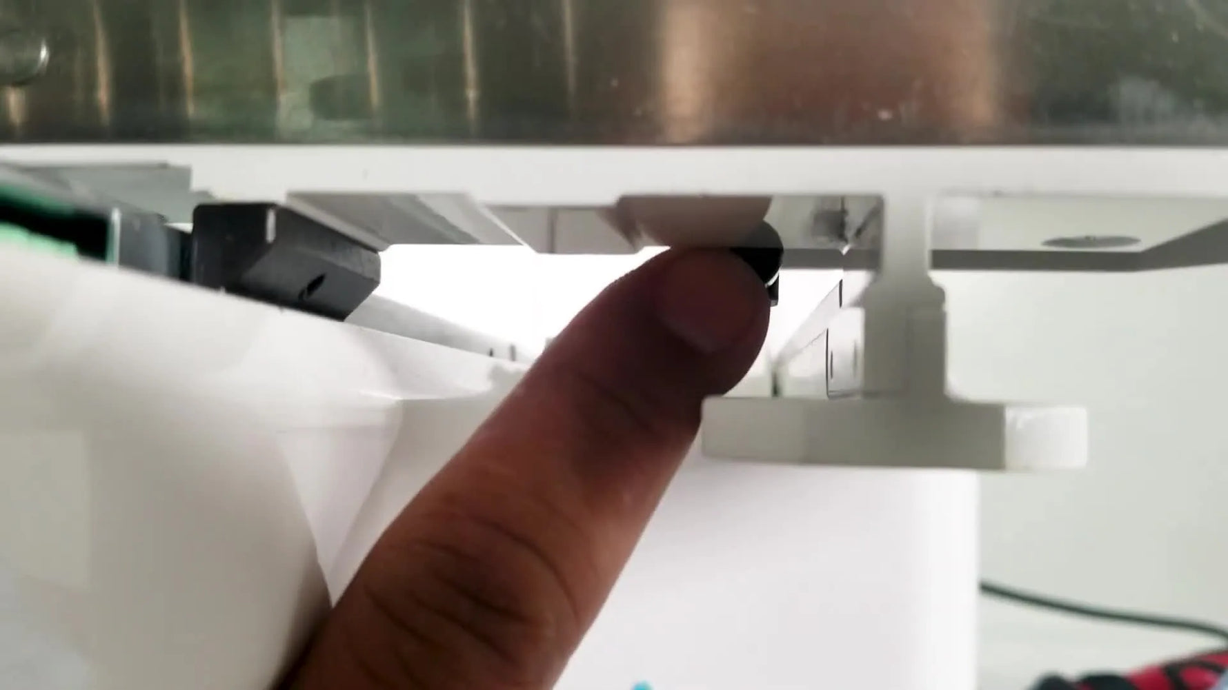 An extreme close-up of the small black cap sensor button that must be physically pressed for the machine to recognize hat mode.