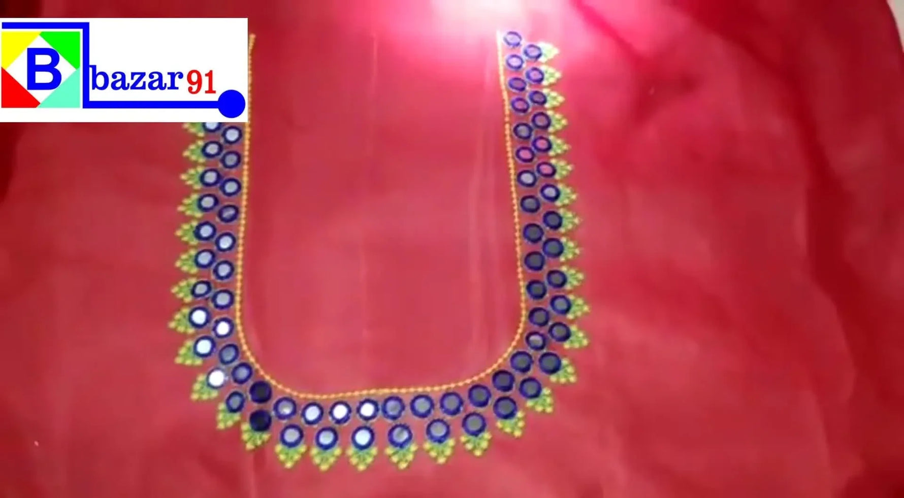 Final embroidered blouse neck design on red fabric.