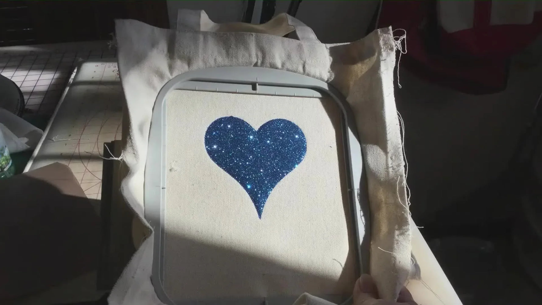 A Brother Luminaire XP1 is set up with a canvas tote bag hooped flat, ready to stitch an applique design cleanly without fighting bulky side seams.