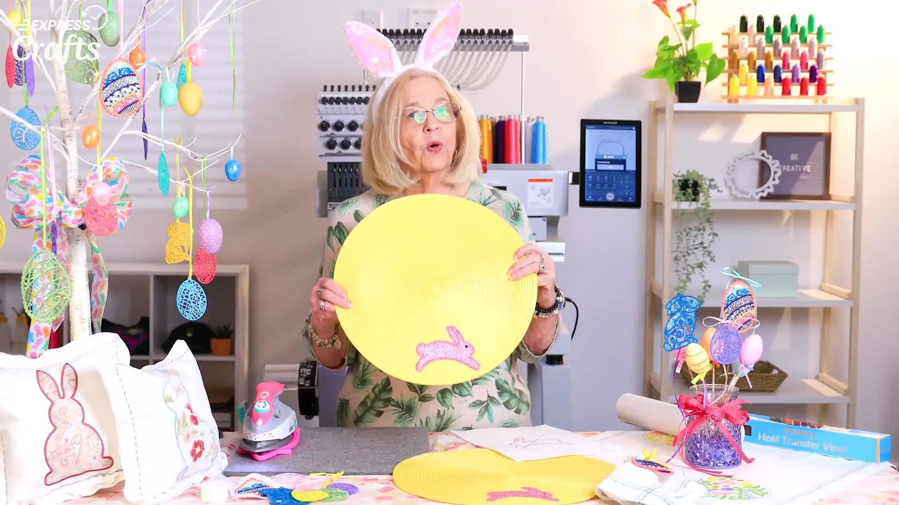 A finished yellow woven placemat featuring a pink glitter vinyl bunny appliqué, held up for a clear final reveal.