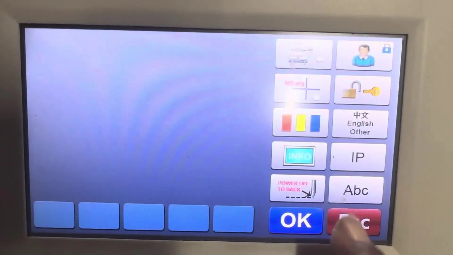 Finger pointing at 'ABC' button on Ricoma menu screen.