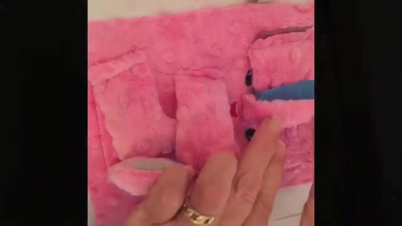 Blue masking tape straps the elephant’s trunk, ears, and limbs tightly into the center of a magnetic hoop so the final seam can stitch without catching bulky parts.