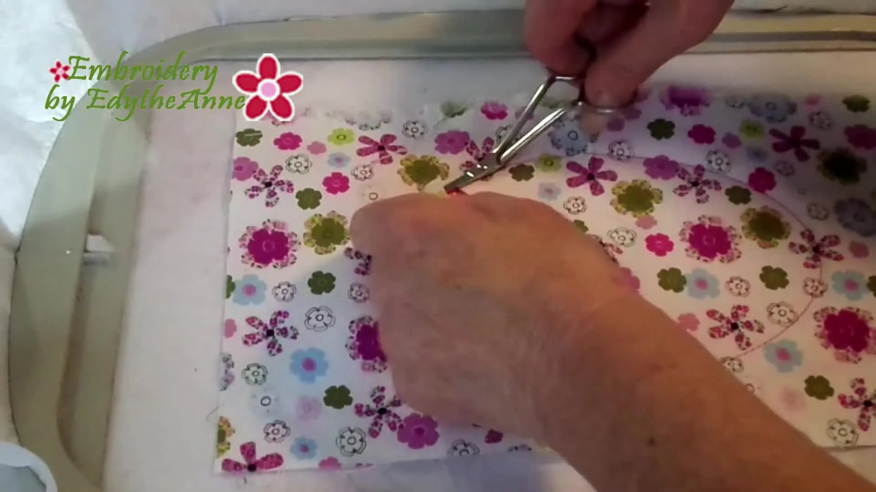 Close-up of trimming the top fabric oval to reveal the base fabric underneath during the reverse applique step.