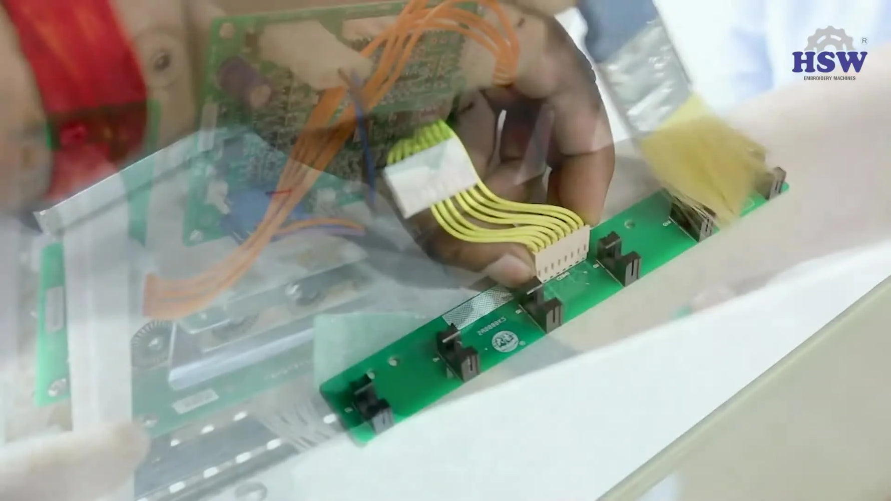 A close-up of a detached green sensor card being brushed clean to restore reliable thread-break detection.