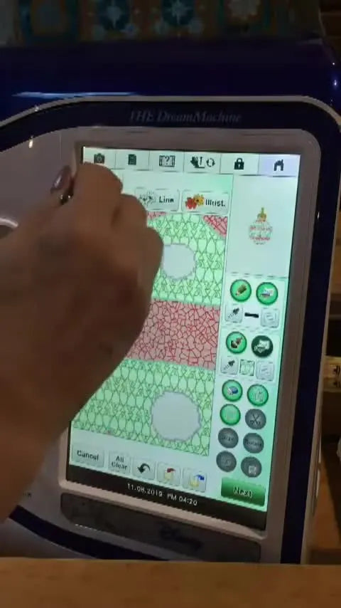 A completed ornament design on the machine screen, filled with gold, red crackle, and green sections, ready to be finished with a satin border.