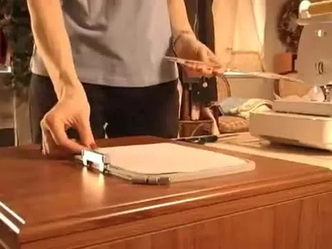 A magnetic frame is being placed over a paper-and-stabilizer sandwich to secure the sheet flat without tape or spray adhesive.