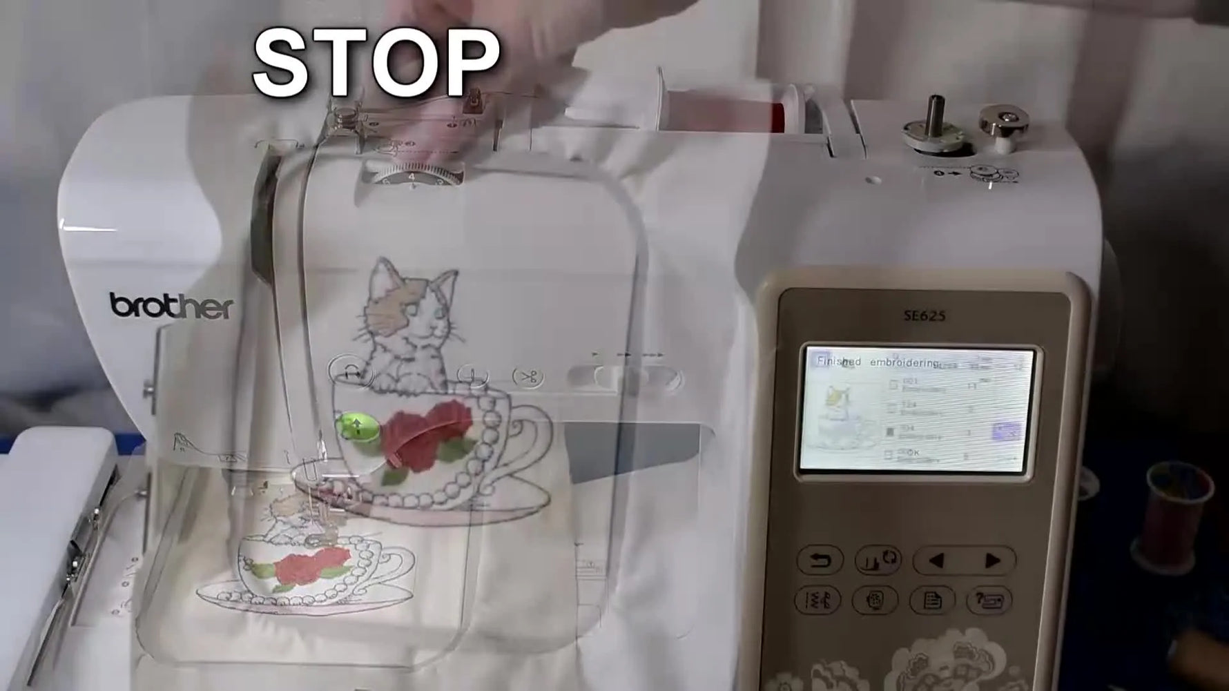 A finished cat-in-a-teacup embroidery design shown still hooped, highlighting clean registration after multiple color changes.