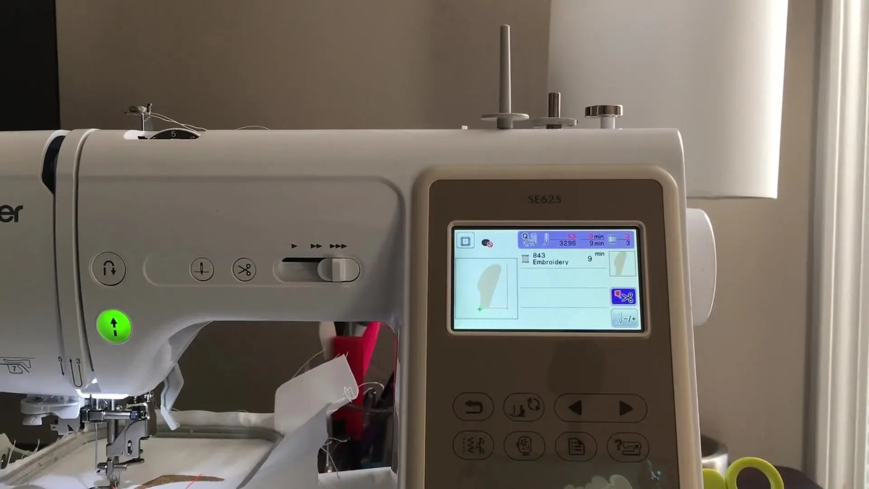 A finished split banana embroidery sits in the hoop with a clean, nearly invisible join between the two hoopings.