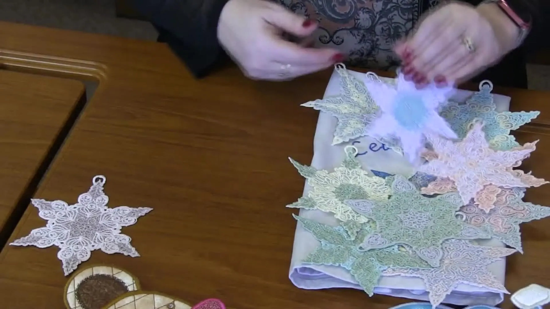 A colorful pile of intricate free-standing lace antique stars, showing crisp stitch detail and ornament-ready loops.