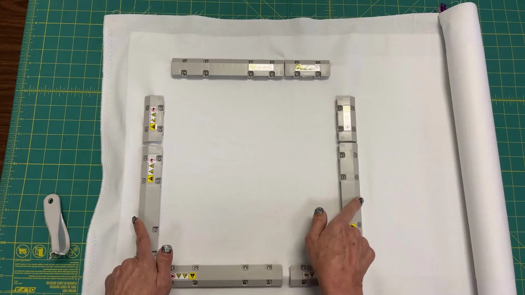 A fully assembled 10x10 magnetic hoop holds a large fabric roll smoothly and evenly, ready for safe mounting on the embroidery machine.
