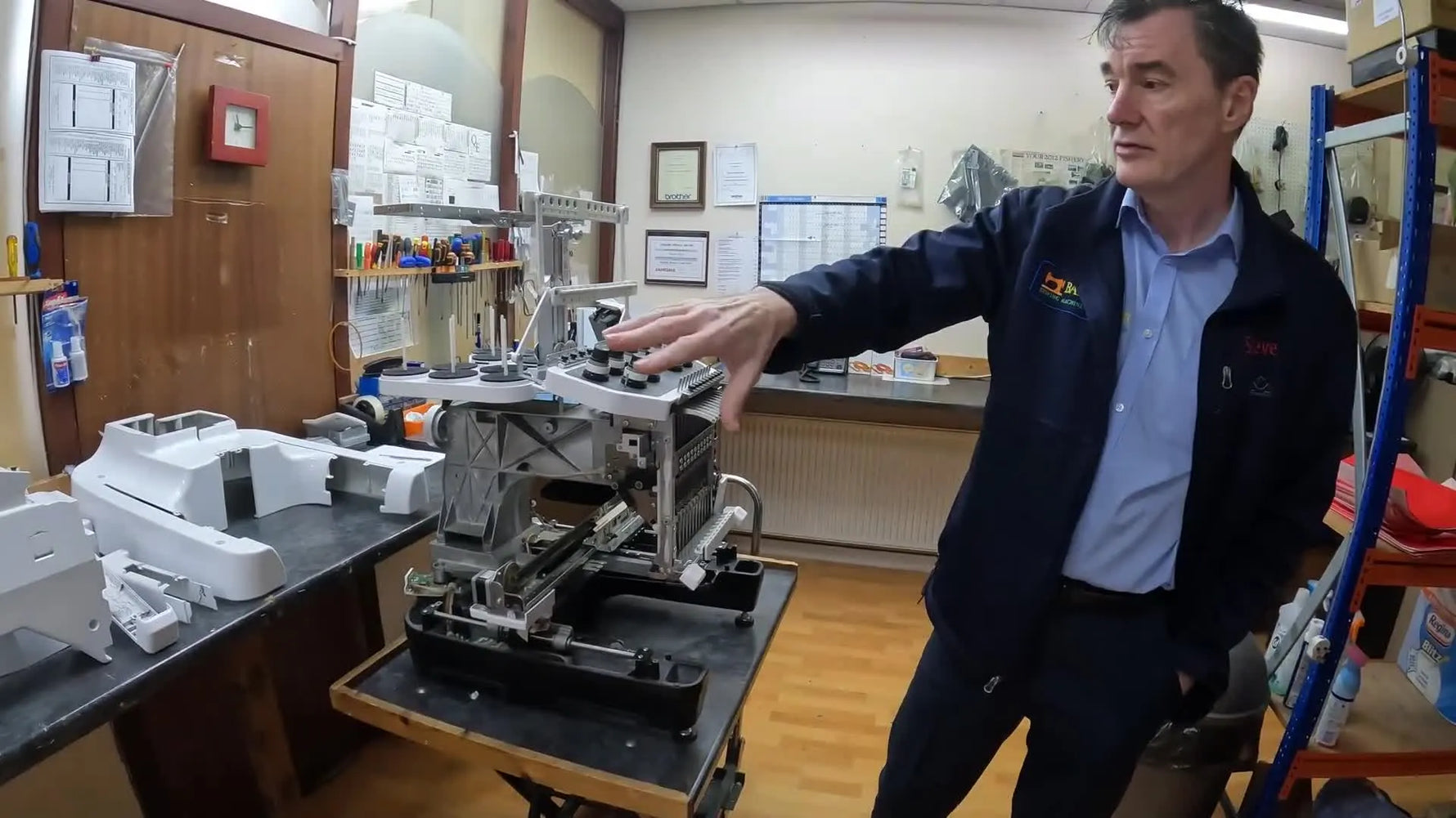 A Brother PR1050X with all outer covers removed, showing the exposed metal chassis and internal components during service.