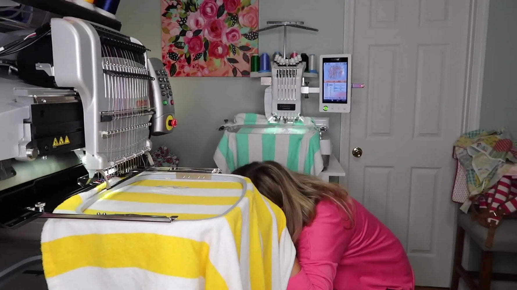 Close-up of curved scissors trimming appliqué fabric inside a hoop while it’s still mounted on the embroidery machine arm.