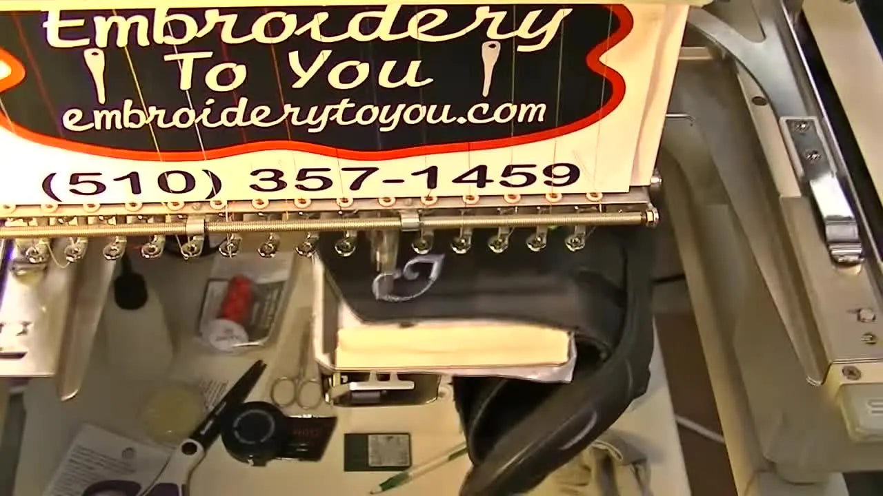 Close-up of a sandal strap secured on a Fast Frame with sticky stabilizer and small spring clamps, ready for embroidery.