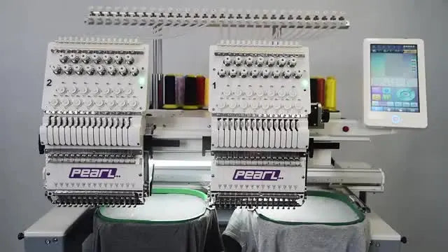 A wide view of the Pearl 2-head commercial embroidery machine set up to stitch two grey T-shirts at the same time.