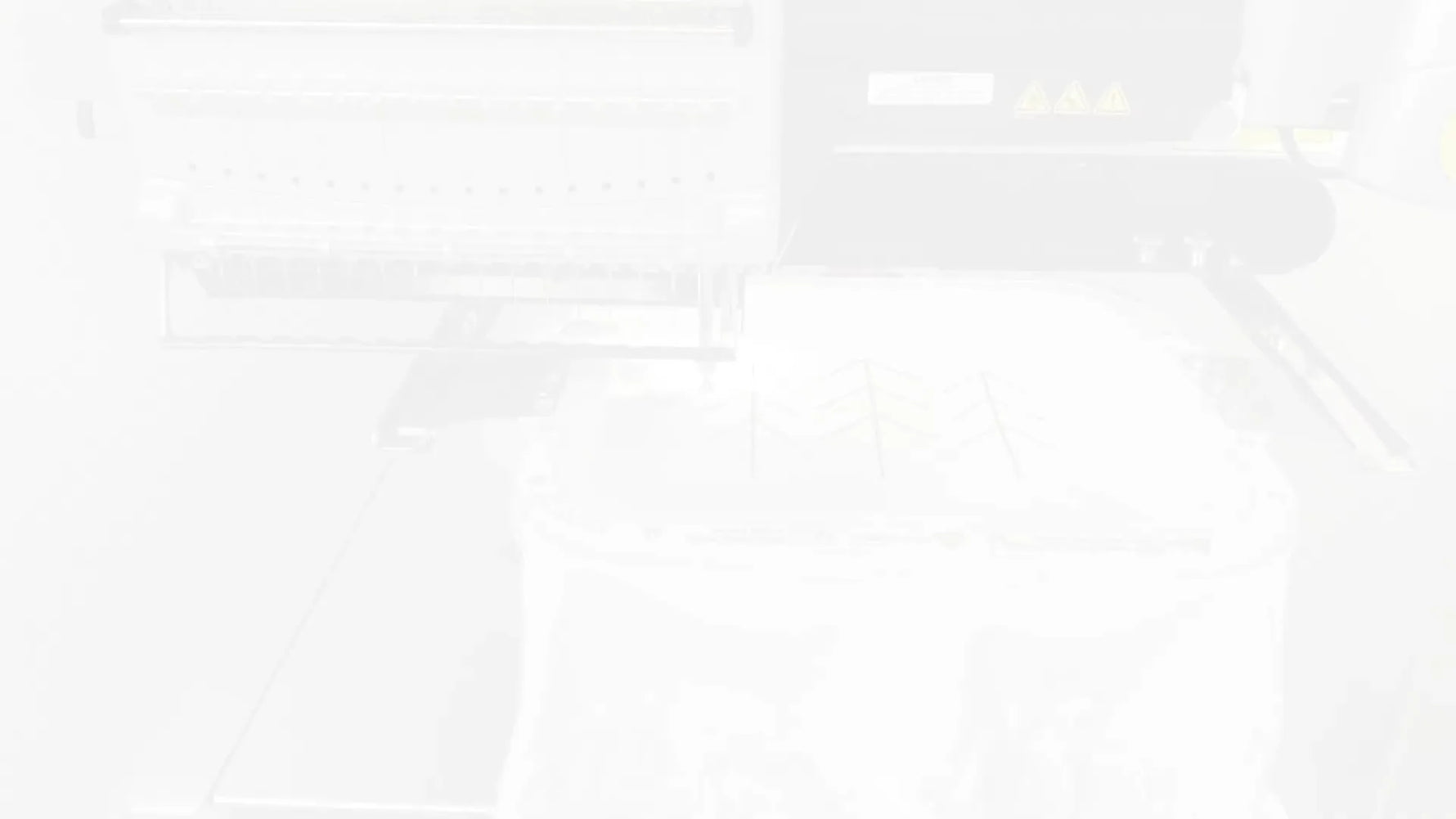 Close-up action shot of the Melco needles stitching the green tree design during the quick-stitch run.