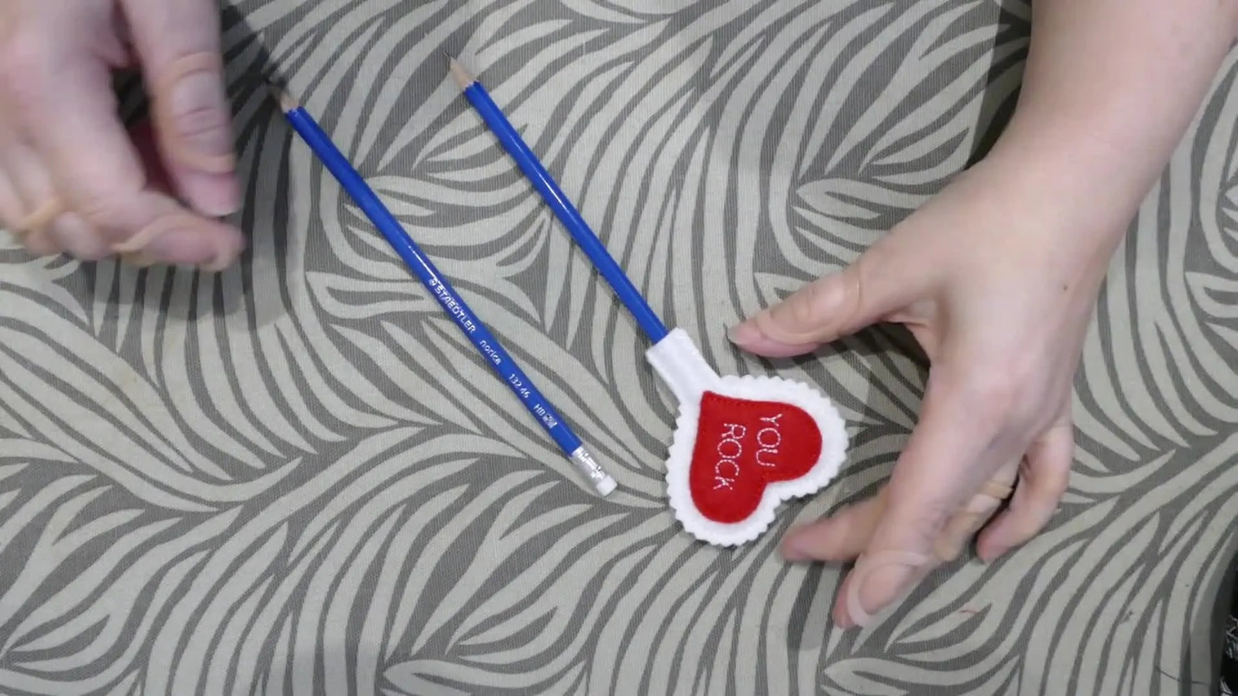 A close-up of finished heart pencil toppers with pencils inserted, showing the chalkboard-backed design ready for personalization.