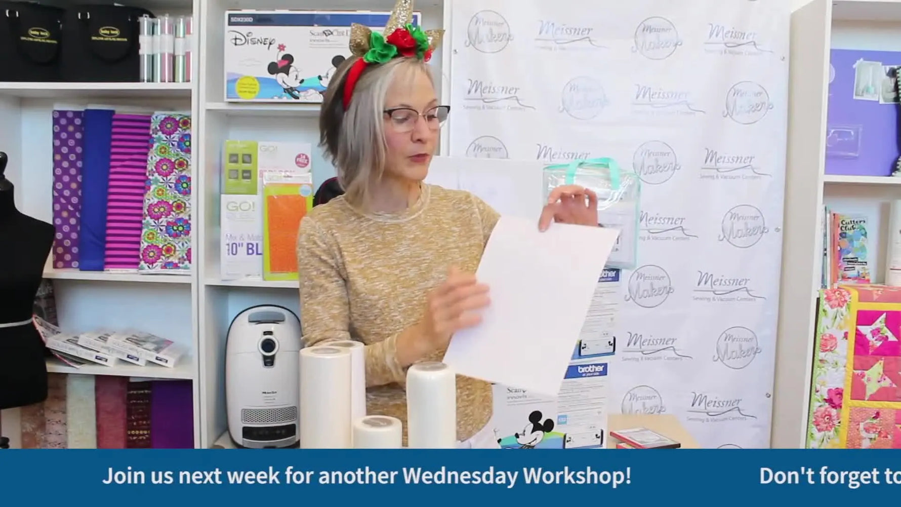 A host holds up a printed Template Tearaway sheet used to audition embroidery placement before stitching.