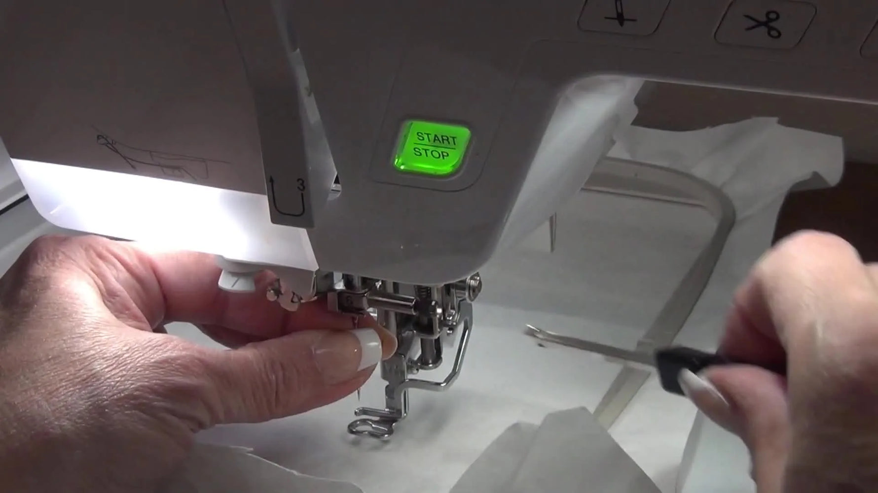 Using a small screwdriver to tighten the needle clamp after inserting a fresh embroidery needle.
