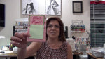 Grace holding up the finished pink vertical Post-It note holder with 'Don't Forget' embroidery.