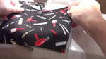 Placing the main black patterned fabric into the hoop before attaching the pocket.