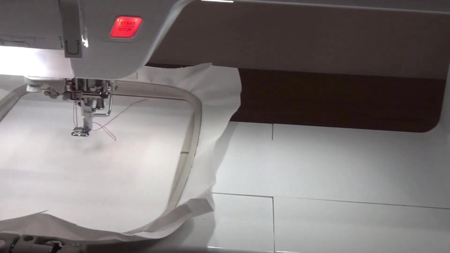 Baby Lock embroidery machine stitching on white tearaway stabilizer hooped in a 5x7 frame.