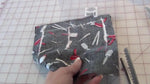 Using pinking shears to trim the excess fabric around the stitched perimeter of the project.