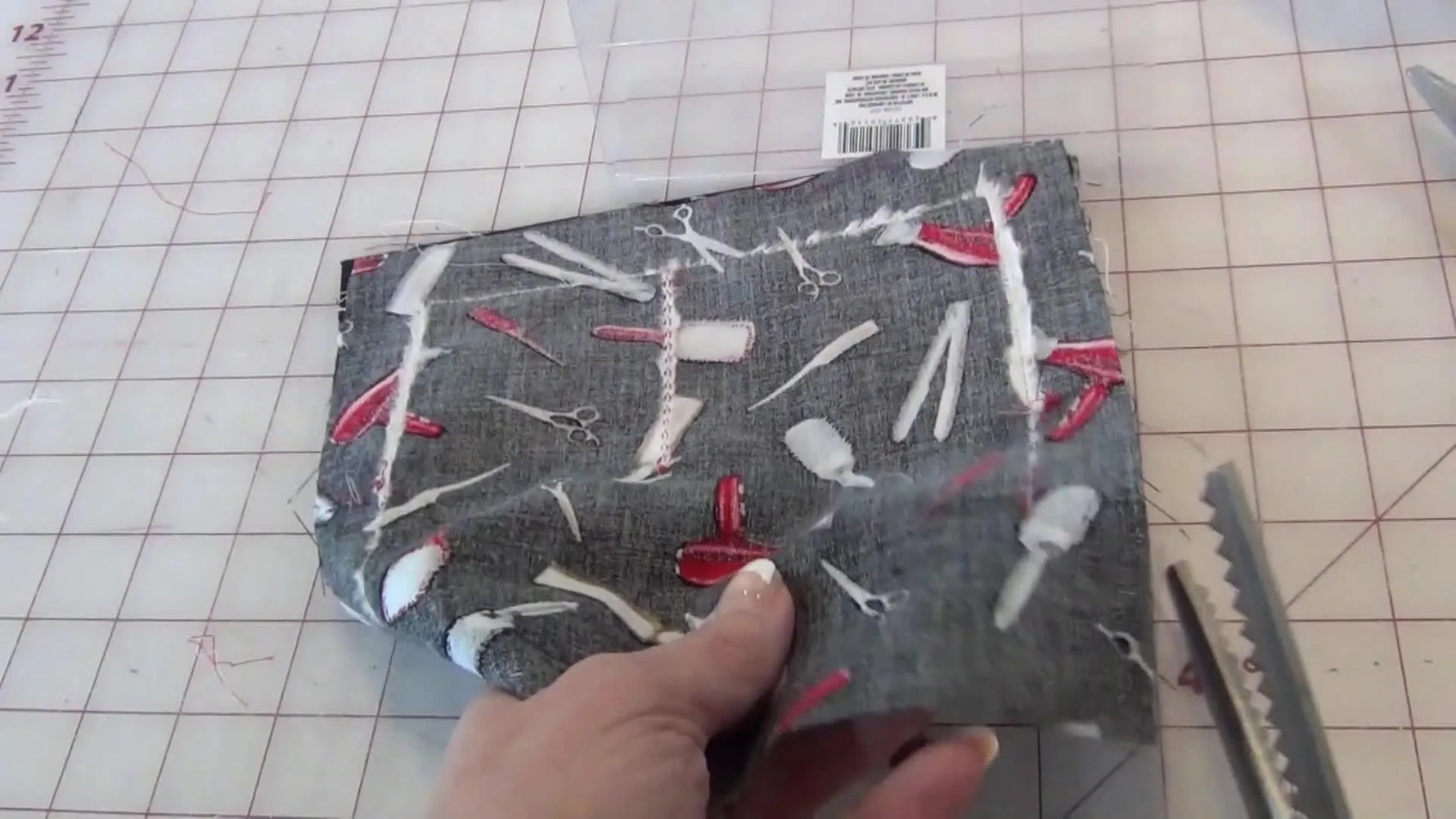Using pinking shears to trim the excess fabric around the stitched perimeter of the project.
