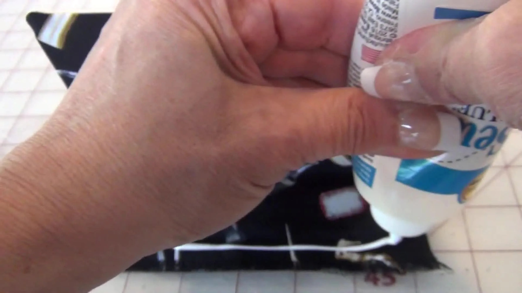 Applying a line of Aleene's No-Sew Fabric Glue to the bottom edge of the fabric.